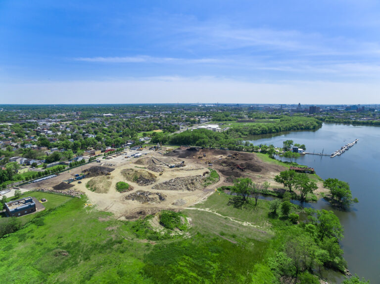 Aerial of a waterfront recycling site in Camden, NJ ringed by trees