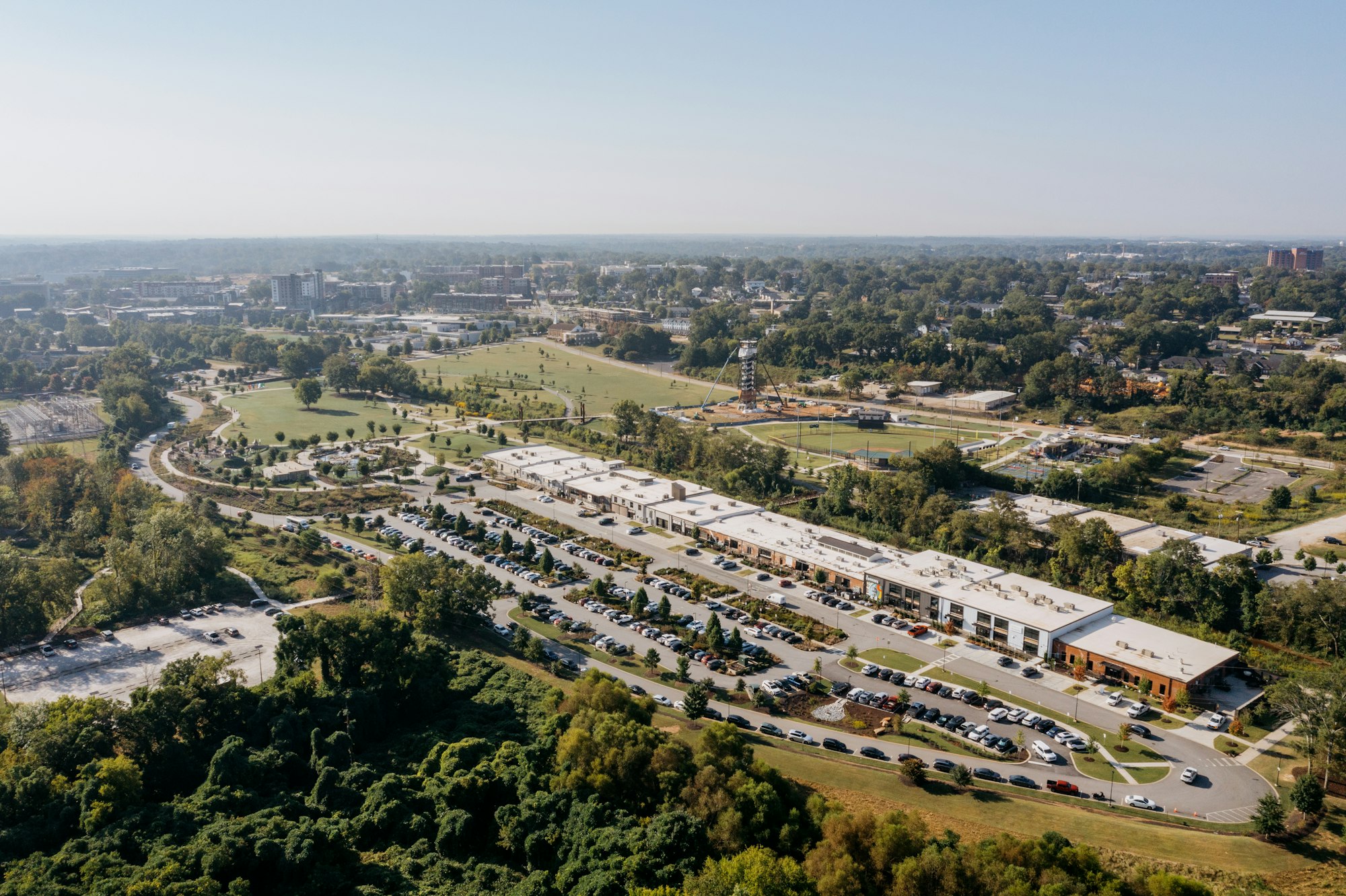 Aerial view of a commercial property and parking lot framed by the surrounding town