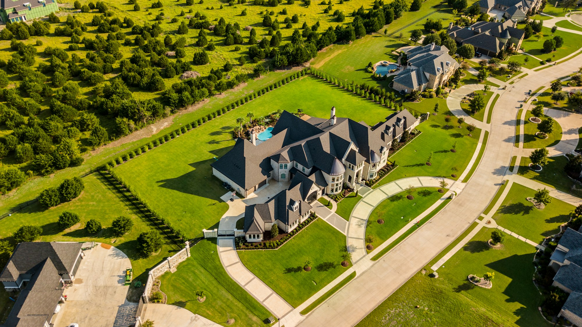 Aerial photo of a luxury estate home, driveway and landscaped grounds