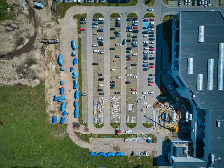 Top-down aerial of a commercial site with parking and buildings