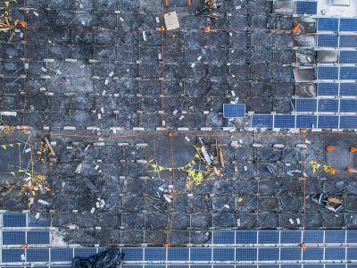 Aerial close-up of scorched rooftop solar panels during an inspection flight
